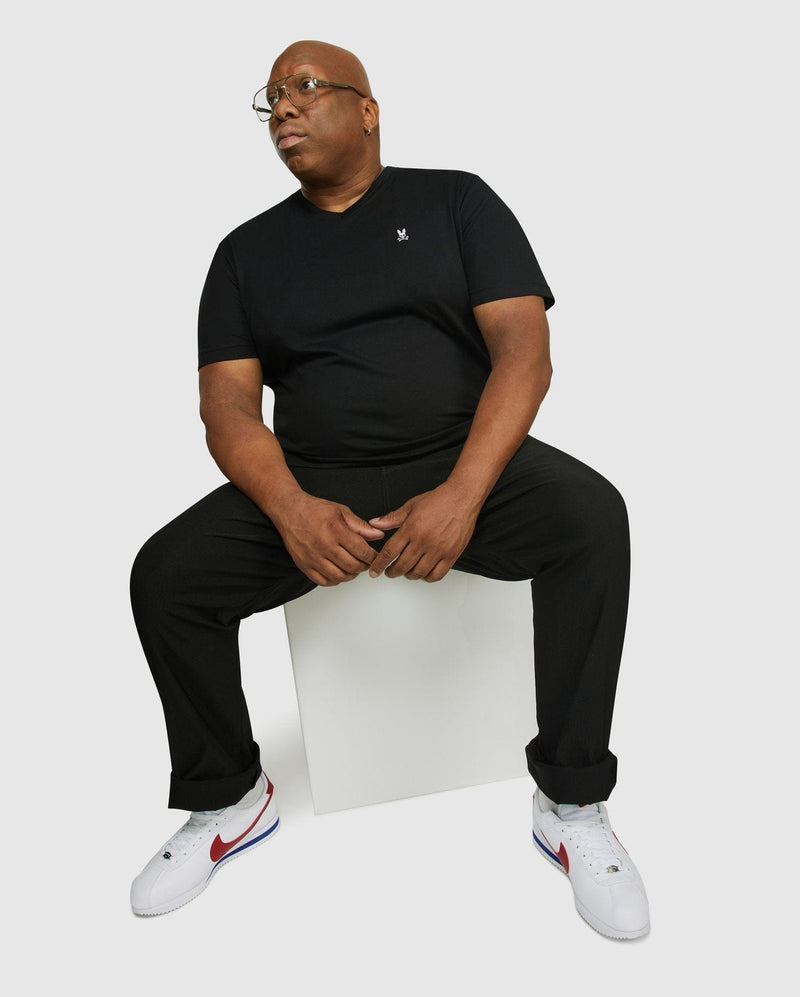 Psycho Bunny Big and Tall Classic V Neck Tee in black, featuring the embroidered logo on the chest, lifestyle seated view.