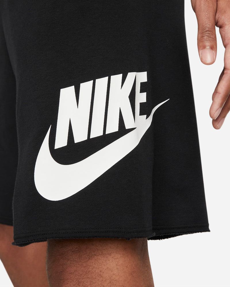 Nike French Terry Alumni Shorts in black with a bold white Nike logo and raw-edge hem, side view.