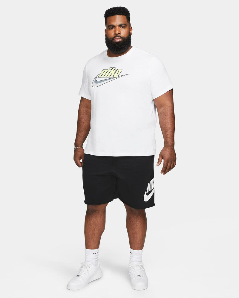Nike French Terry Alumni Shorts in black with white Nike logo and relaxed fit, worn in a standing lifestyle context.