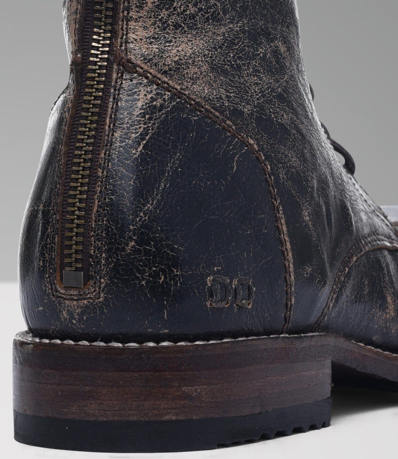 Bed Stu Protege boots in distressed black leather with exposed back zipper, stitched detailing, and wooden sole, rear close-up view.